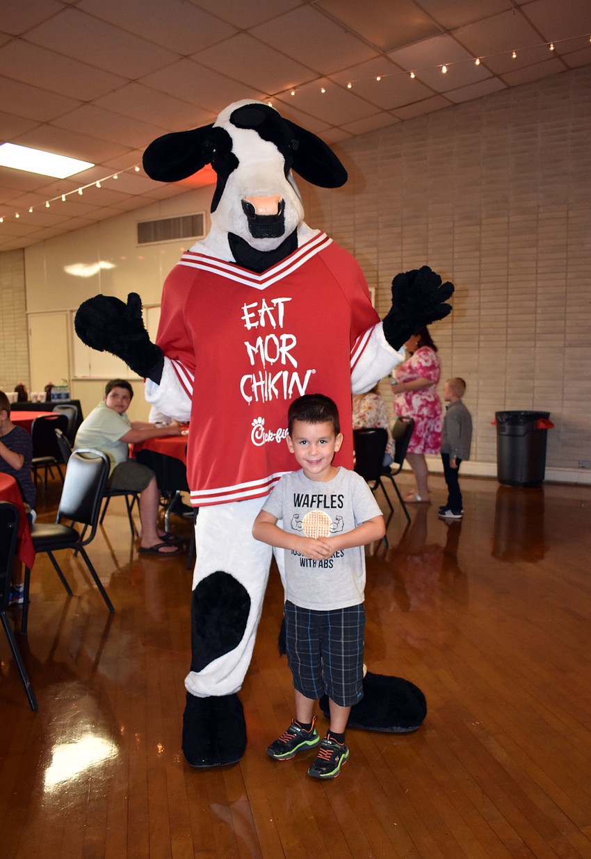Garrett Amundsen smiles with a Chick-Fil-A cow.