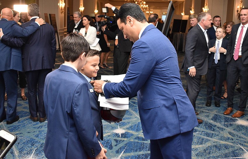 Kevin Negandhi signs basketballs for fans.