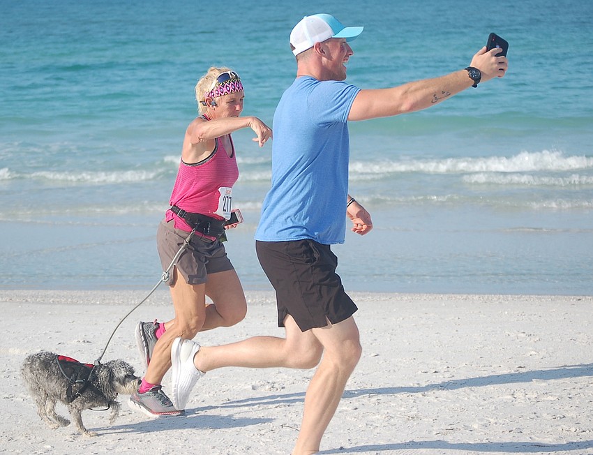 Garrett Blair paces Patti Stanley near the finish line while streaming the action live. Lucy also came along for the 5K.