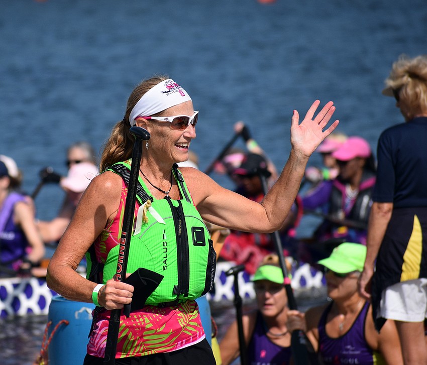Venice resident Joni Carone collects high-fives on her way off the boat after Survivors in Sync won a race.