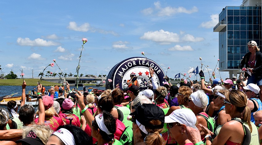 Rowers held up pink flowers while 