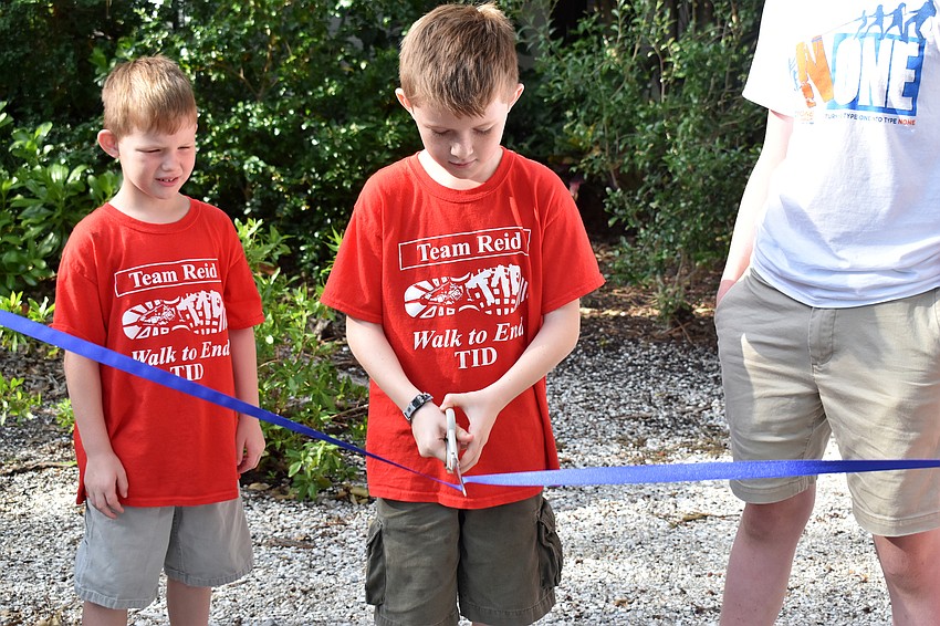 Reid Kennedy cuts the ribbon to start the walk.