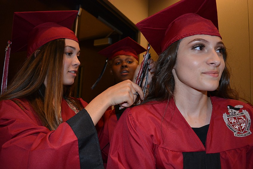 Andrea Eberstein helps Gabrielle Cornelius adjust her tassel before the ceremony begins.
