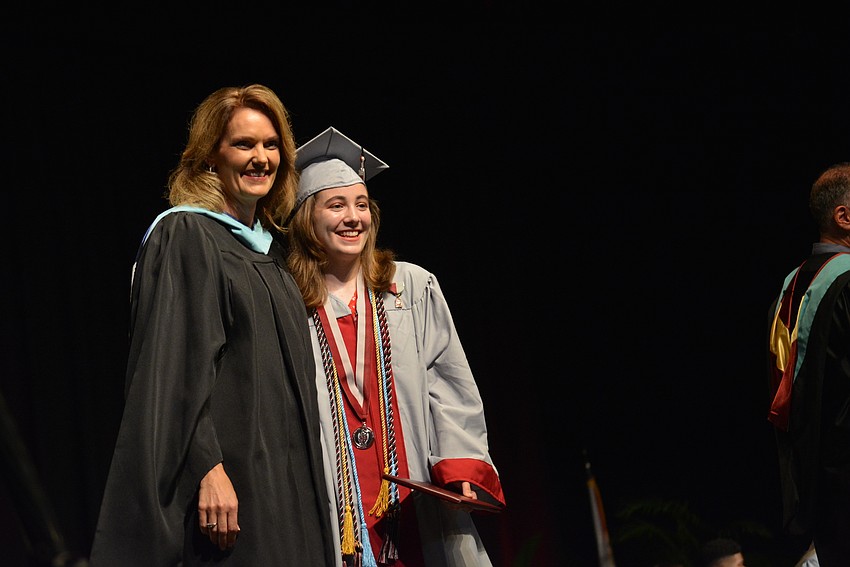 Principal Sharon Scarbrough poses with Abigal Klaben after moving her tassel. Klaben graduated in the top 4% of her class and with other honors.