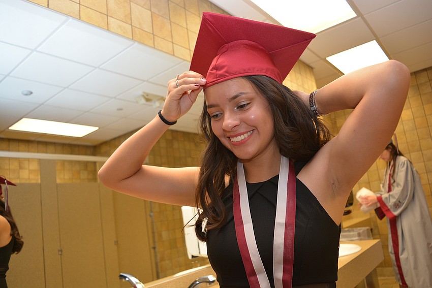 Nicole Munoz, 19,  adjusts her cap and robe fore lining up for the ceremony.