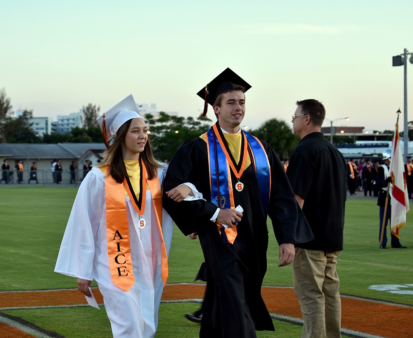 Graduates meet up in the middle of the field before heading to their seats.