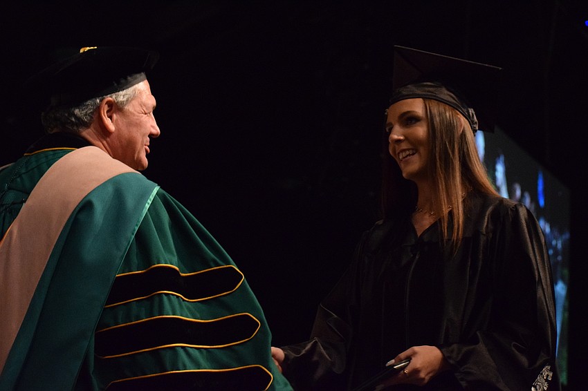 School board member Scott Hopes congratulates graduate Rachel Latka.