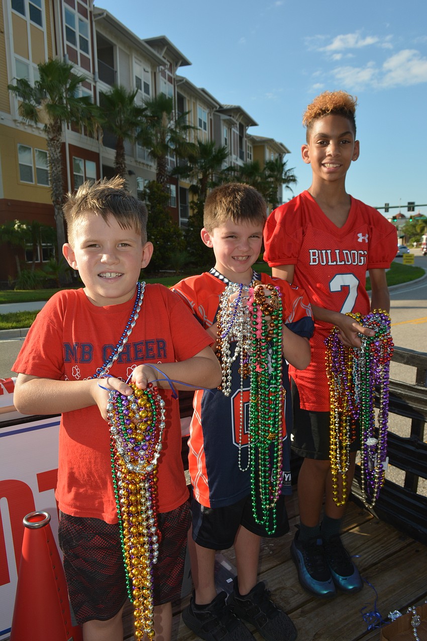 Eight-year-old Jaxon Miklavic, 8-year-old Dominick Carroll and 11-year-old Zachary Post are ready to represent East Manatee Bulldogs and throw beads during the parade.
