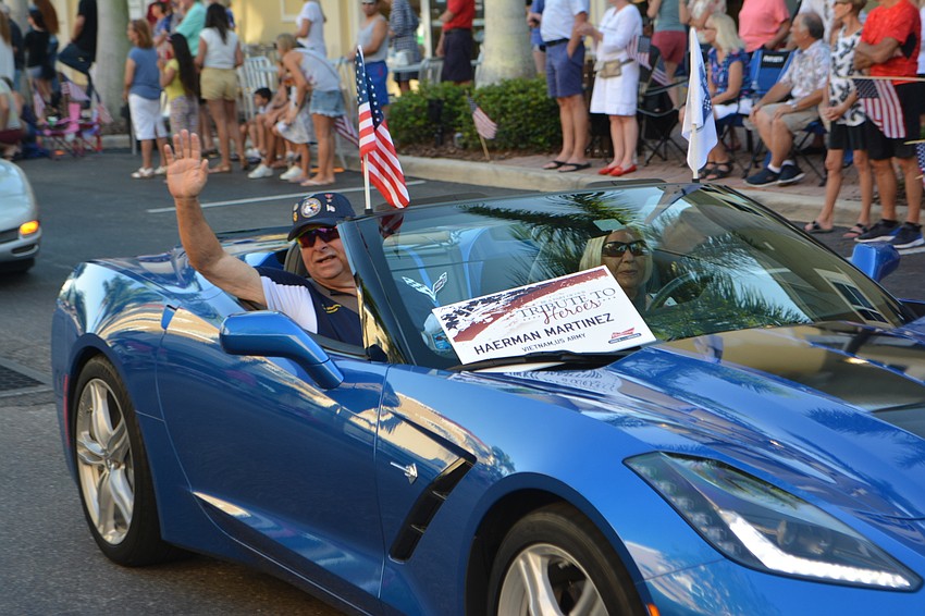 Del Webb's Herman Martinez, a Vietnam veteran, waves to the crowd.