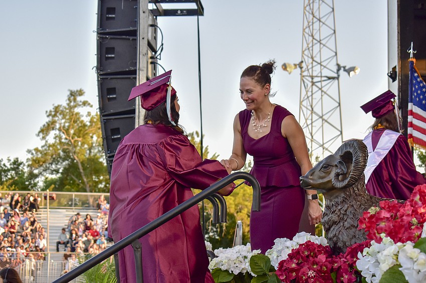 Principal Erin del Castillo shakes the hand of a graduate.