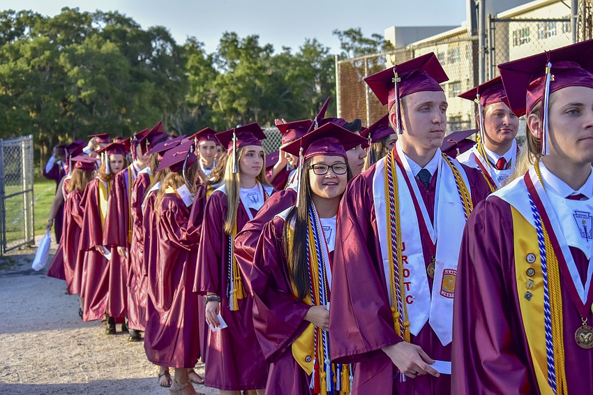 Graduates line up off the field before the processional begins.