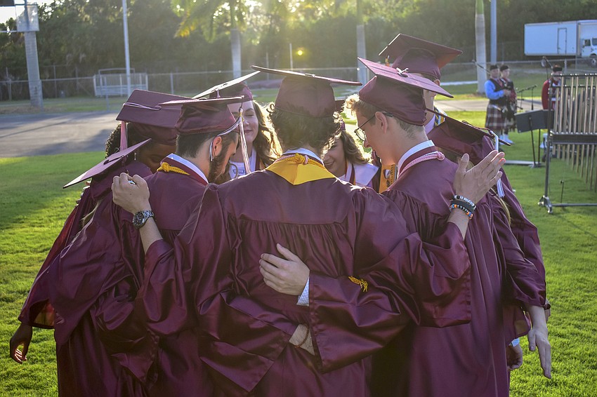 Members of Riverview High School's chamber choir huddle for a prayer before singing the 
