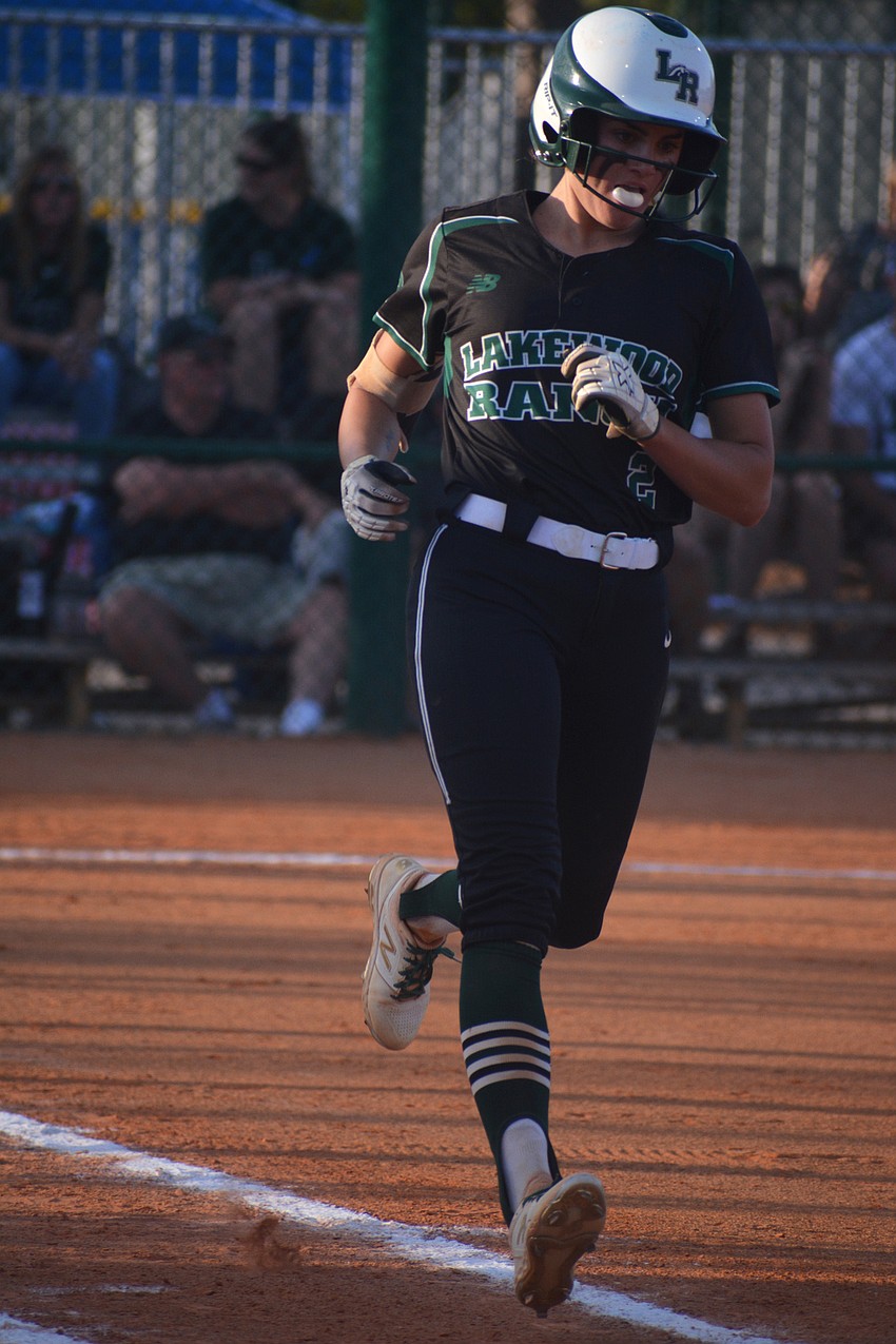 Junior Avery Goelz blows a bubble jogging to first base after grounding out in the fifth inning.