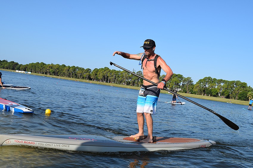 Mike Coleman, of Sarasota, prepared to dismount his paddle board and finish the paddle boarding section.