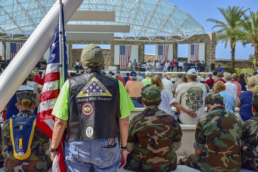 A United States Air Force veteran holds an American Flag at the ceremony.