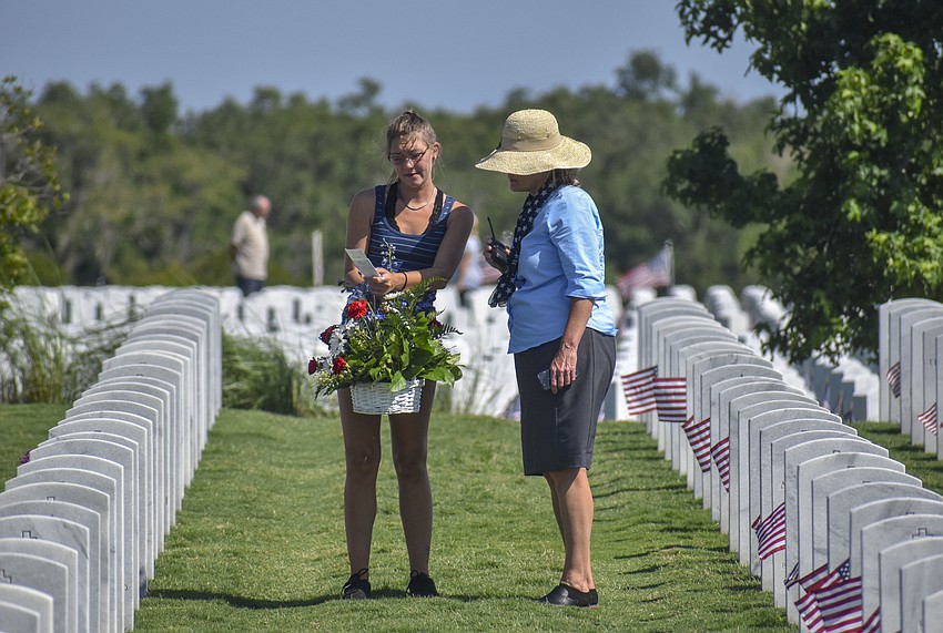 Family members walk through the gravesite to place flowers on graves.