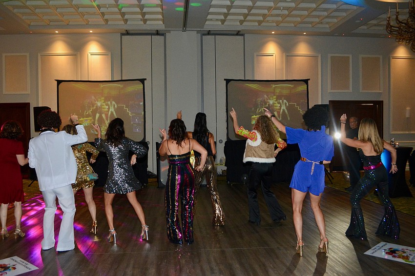 Attendees lined up on the dance floor to do the Hustle