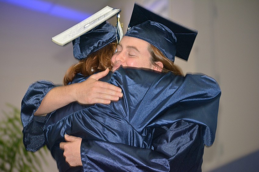 Maria Miller hugs Valedictorian Adelaide Mahler before Mahler addressed the graduating class.
