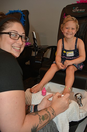 Lakewood Ranch 5-year-old Charlotte Wells has her toenails painted by cosmetologist Aubrie Stevens.