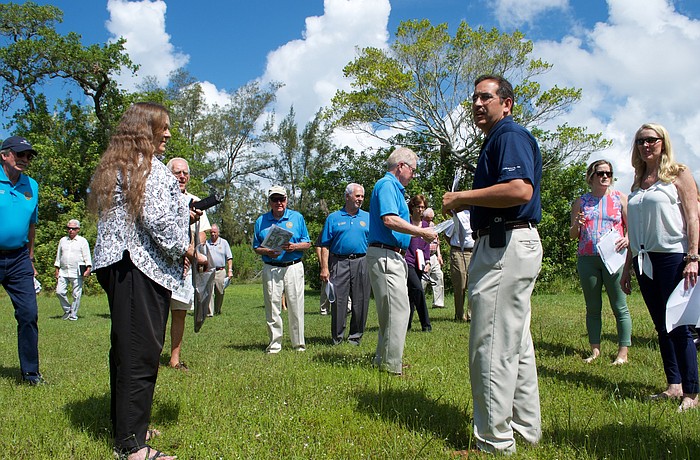 Public Works Director Isaac Brownman, center in the blue shirt, explains to commissioners and members of the public about the plot of city owned land on which they stand.