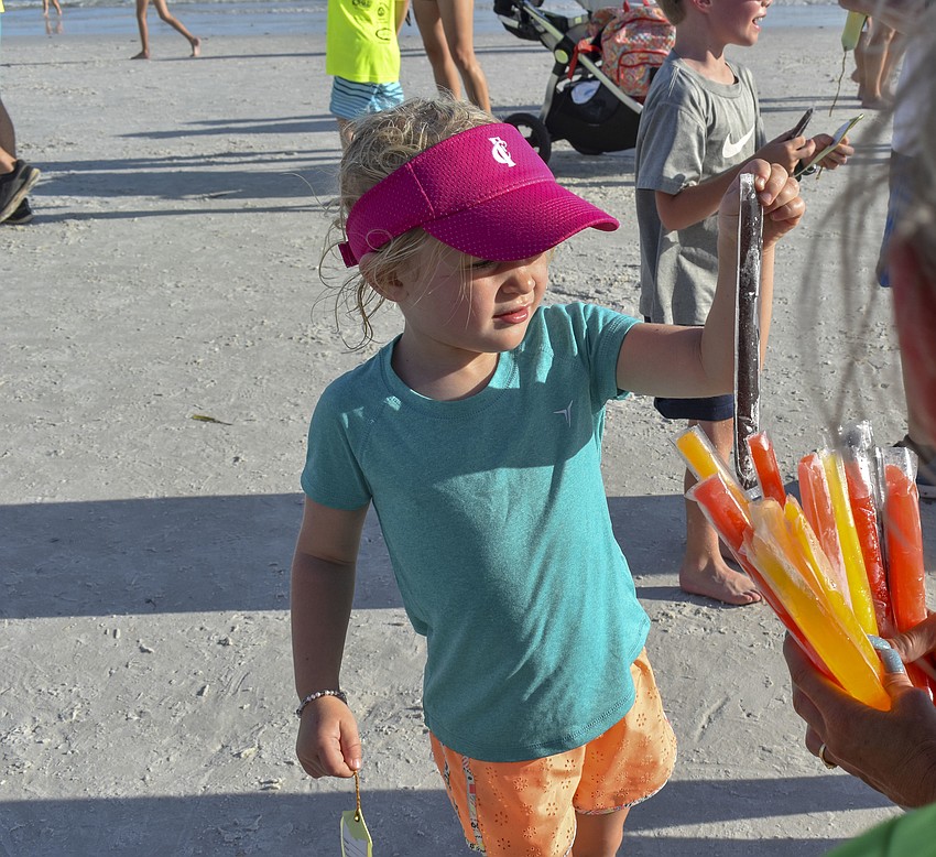 Casper Gruters, 3, takes a popsicle after finishing her race.