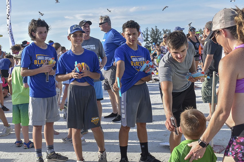 Will Larkin, Daniel Cole, Freddie Morales and Scott Lane pass out popsicles to the runners.