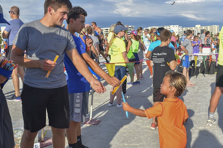 Scott Lane hands a popsicles to one of the runners.