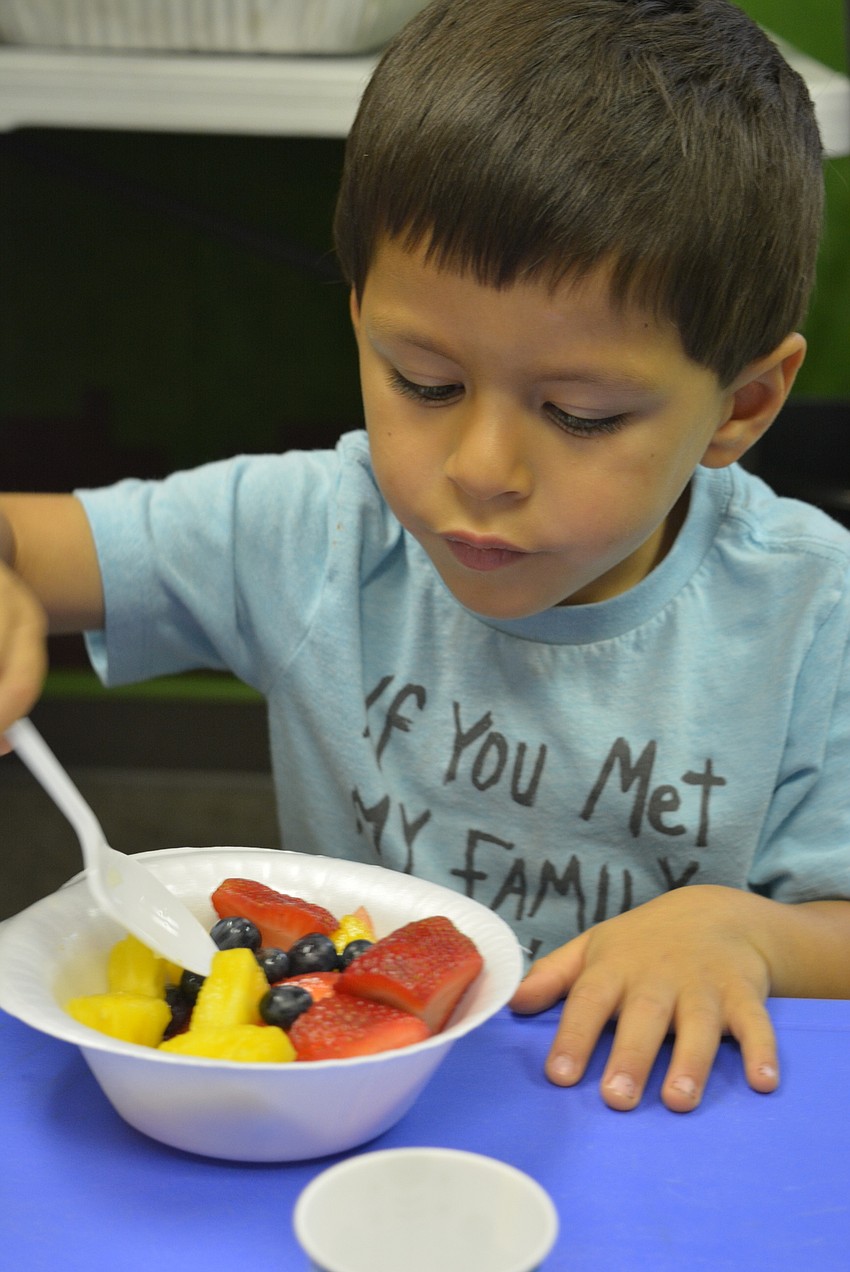 Four-year-old Evan Parton digs into a healthy post-dinner snack after several VBS activities.