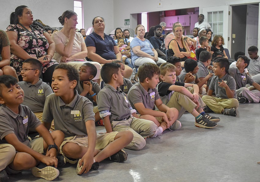 The second and third grade class watch the younger students perform.