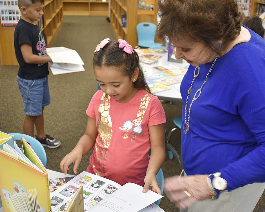 Ghia Fuantase, 6, shows her book choice to Sheila Birnbaum, volunteer project manager for Jewish Family and Children’s Service of the Suncoast.