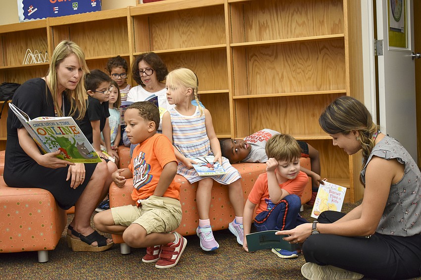 The kindergarten and first graders read their new books with their teachers.