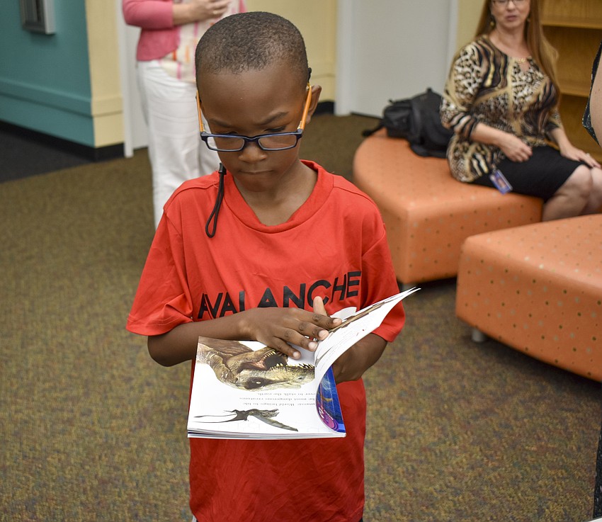 Chiante Townsend, 7, chooses a new book about dinosaurs.