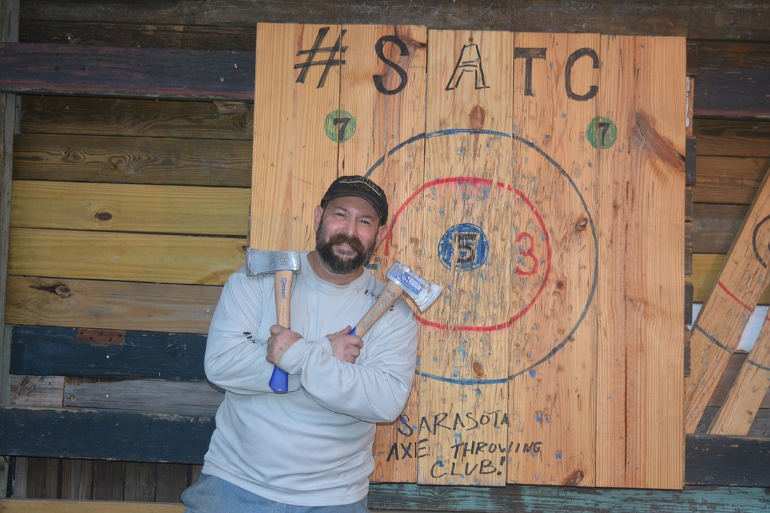 Howie Hochberg poses in front of a Sarasota Axe Throwing Club target.