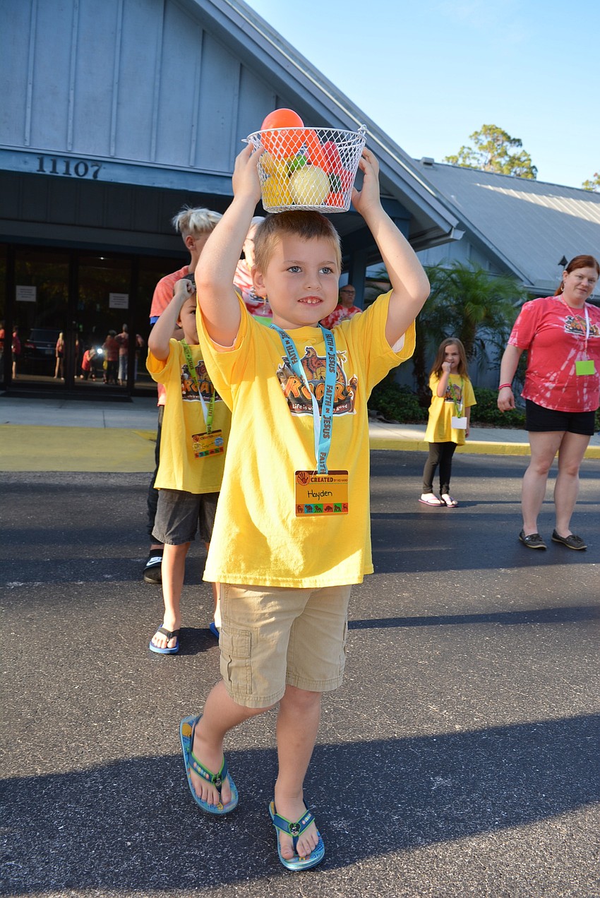 Five-year-old Hayden Hall walks slowly to keep his basket from falling.