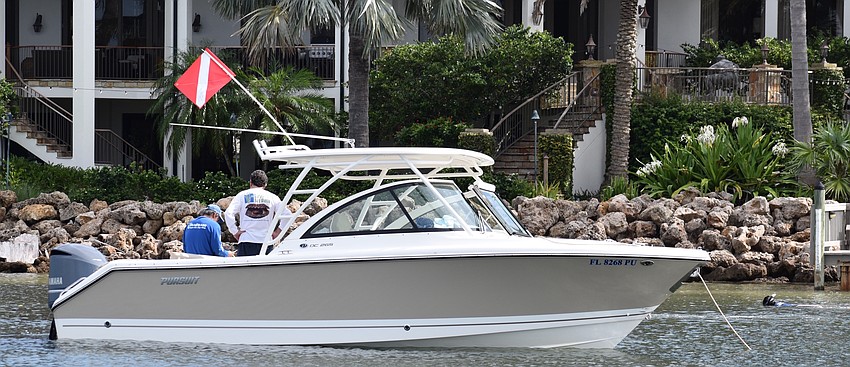 A boat with survey volunteers works near shore south of Ringling College.