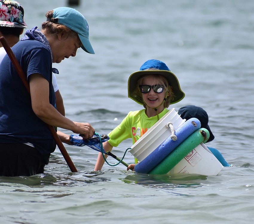 Annie Cederberg and Greyson Giguere check out some of the creatures they found in the water.