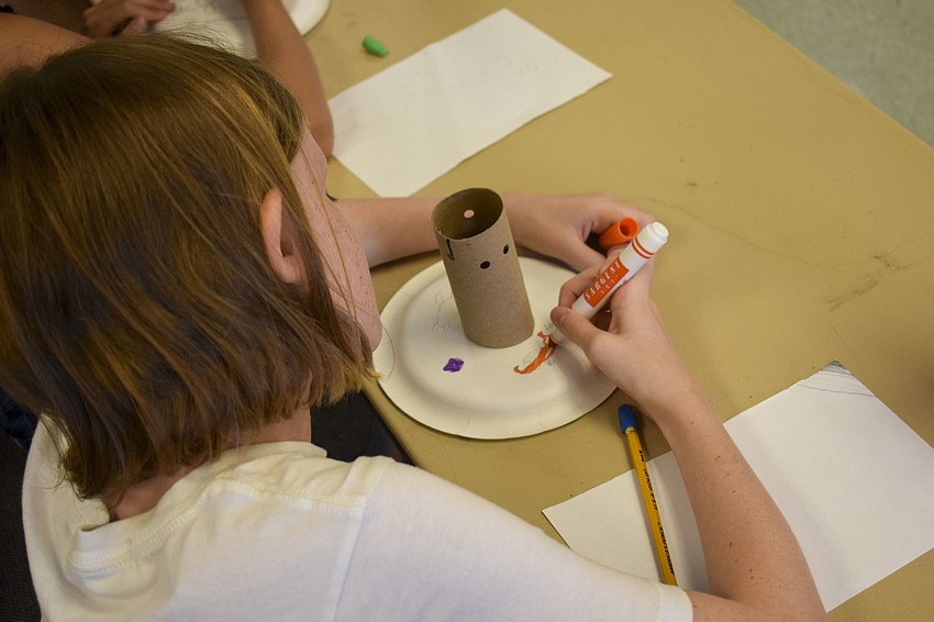 Sydney Cramer draws a seahorse to decorate her coral polyp.