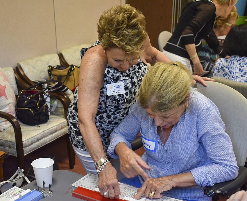 Carol Peschel, left, helps Kathy Gricius with her hand.