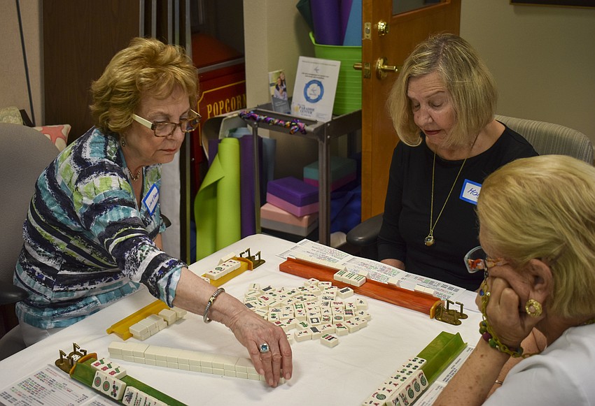 Genie Aberson draws a tile from the wall during her turn.