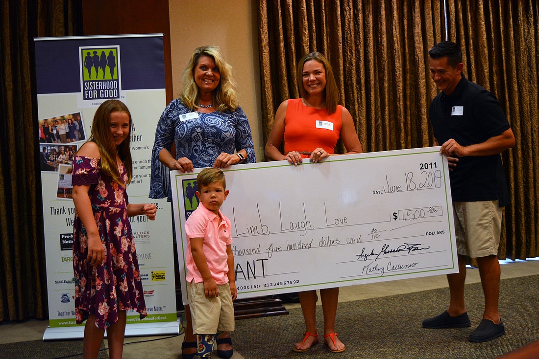 Giving Circle member Peggy Kronus, in blue, gives a $1,500 grant to Myakka-based Limb, Laugh and Love, represented by (left to right) Taylor and Colton  Lawson, April Costello and Chris Lawson.