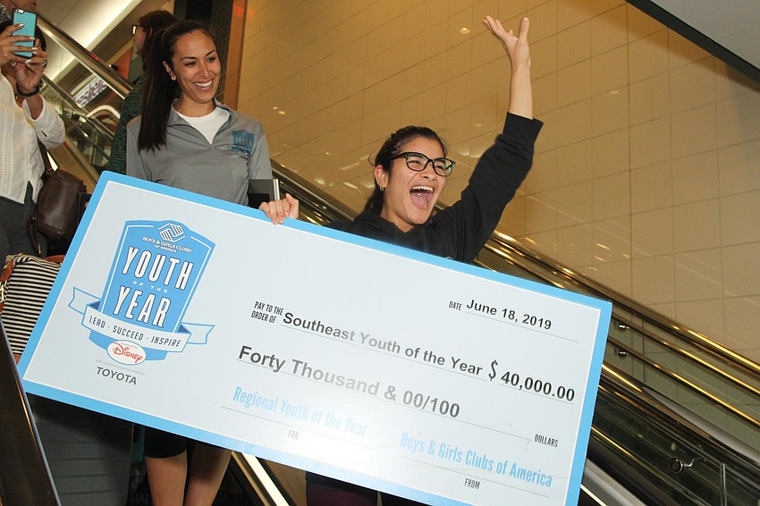 Leonela Tase Sueiro heads down the escalator to the cheers of her friends and supporters.