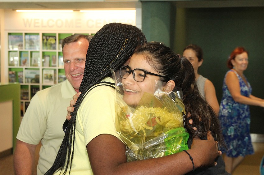 Tyanna embraces Leonela Tase Sueiro after she stepped off the escalator.