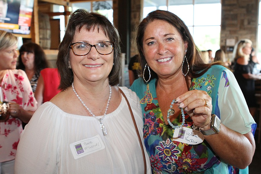 Barbara McSweeney awards Victoria Van Dine with one of her bracelets.