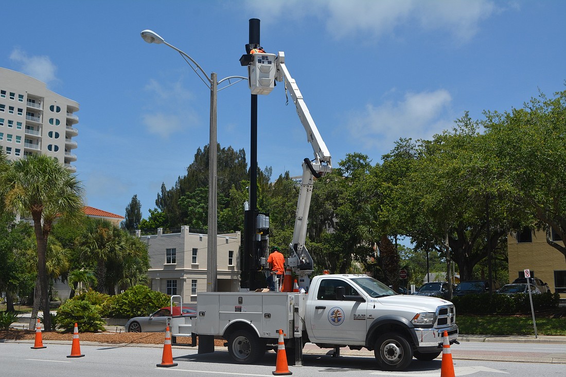 Workers from HP Communications Incorporated perform work on a small cell tower located on Ringling Boulevard