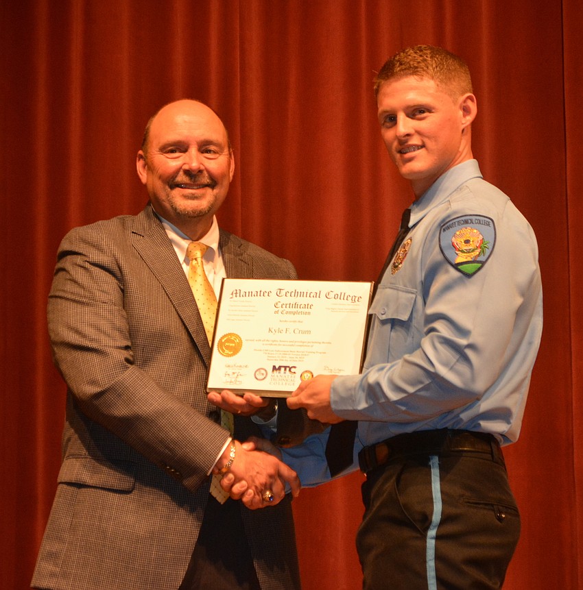 Kyle Crum receives his certificate for completing the Florida Law Enforcement Academy at Manatee Technical College from Academy Director Jay Romine.
