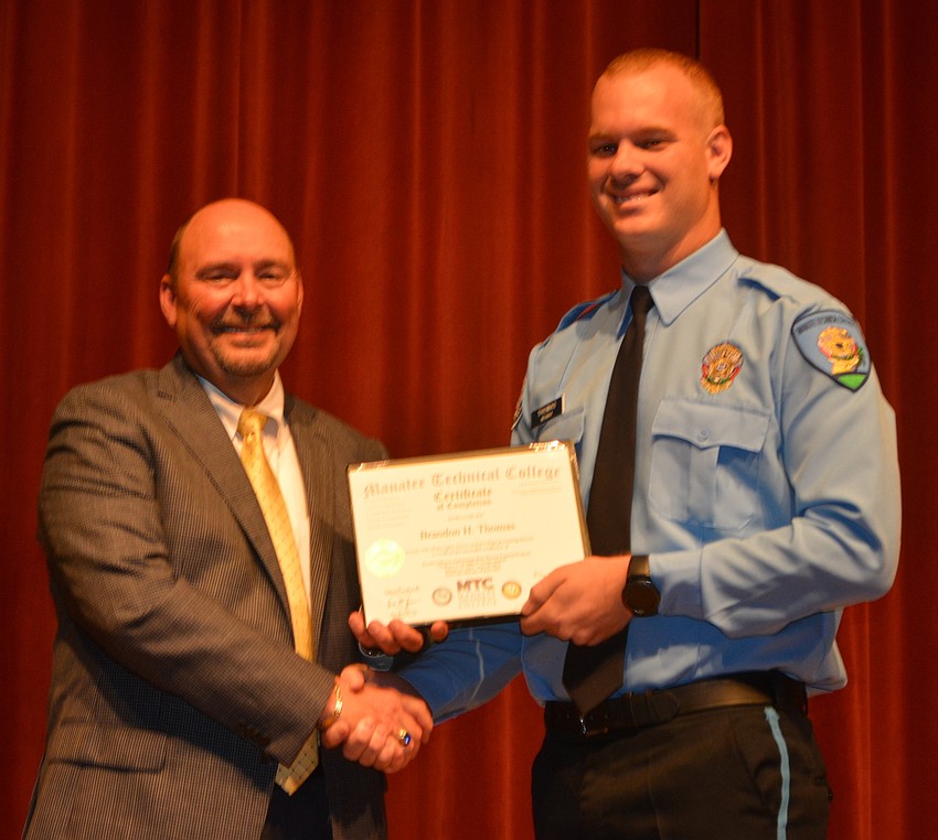 Brandon Thomas receives his certificate for completing the Florida Law Enforcement Academy at Manatee Technical College.