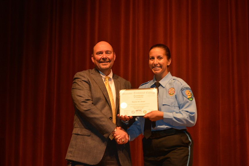 Baylee Bauer receives her certificate for completing the Florida Law Enforcement Academy at Manatee Technical College.