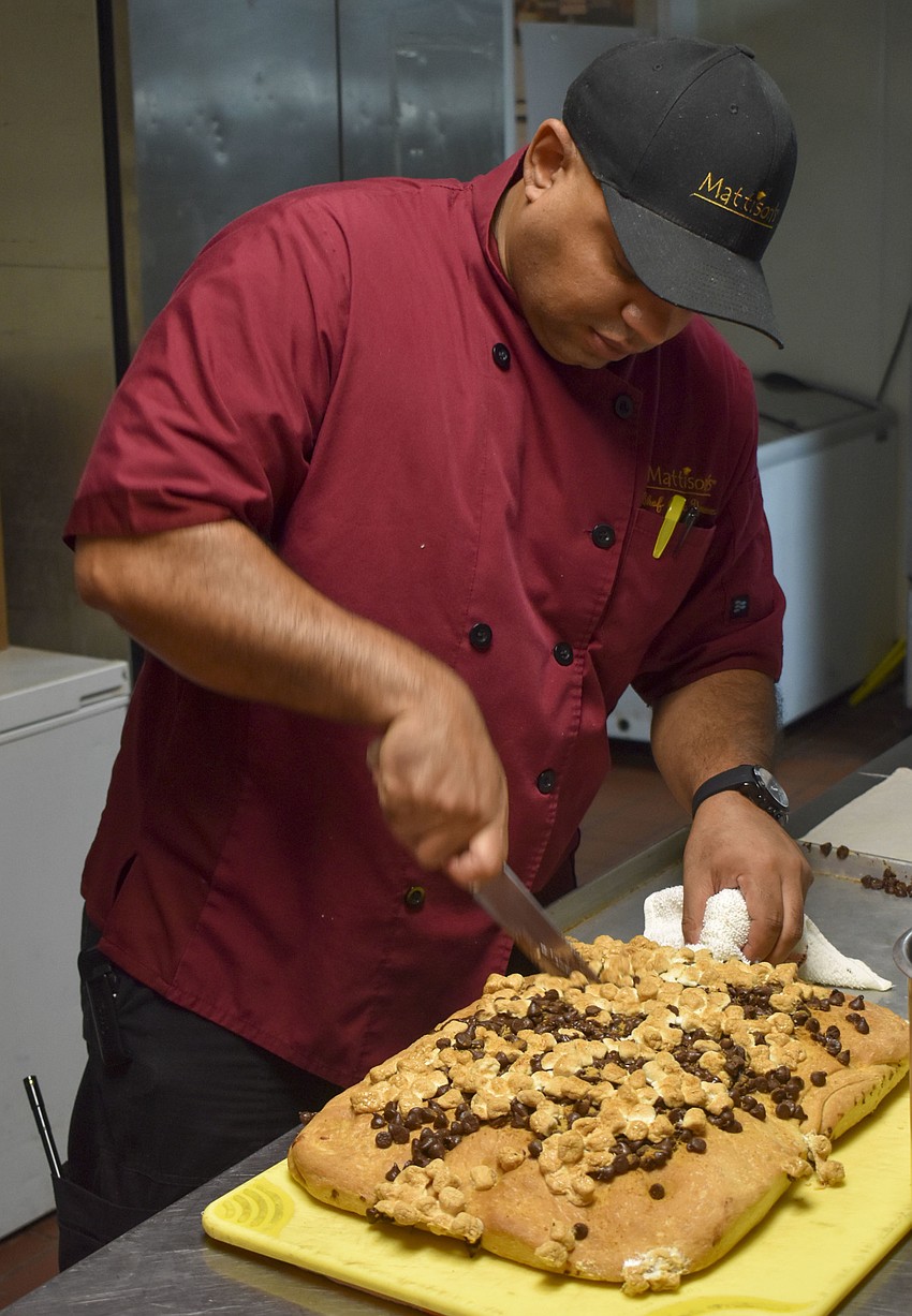 Chef Alex Vasquez cuts the s'mores focaccia bread made by the campers.