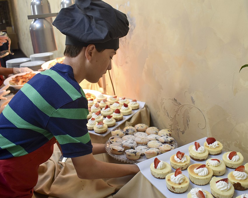 Patrick Van Eyck carries out the blueberry muffins that he covered in powdered sugar.