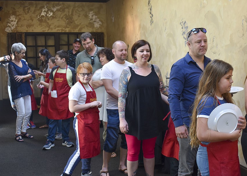 Family and campers line up to grab food from the buffet line.